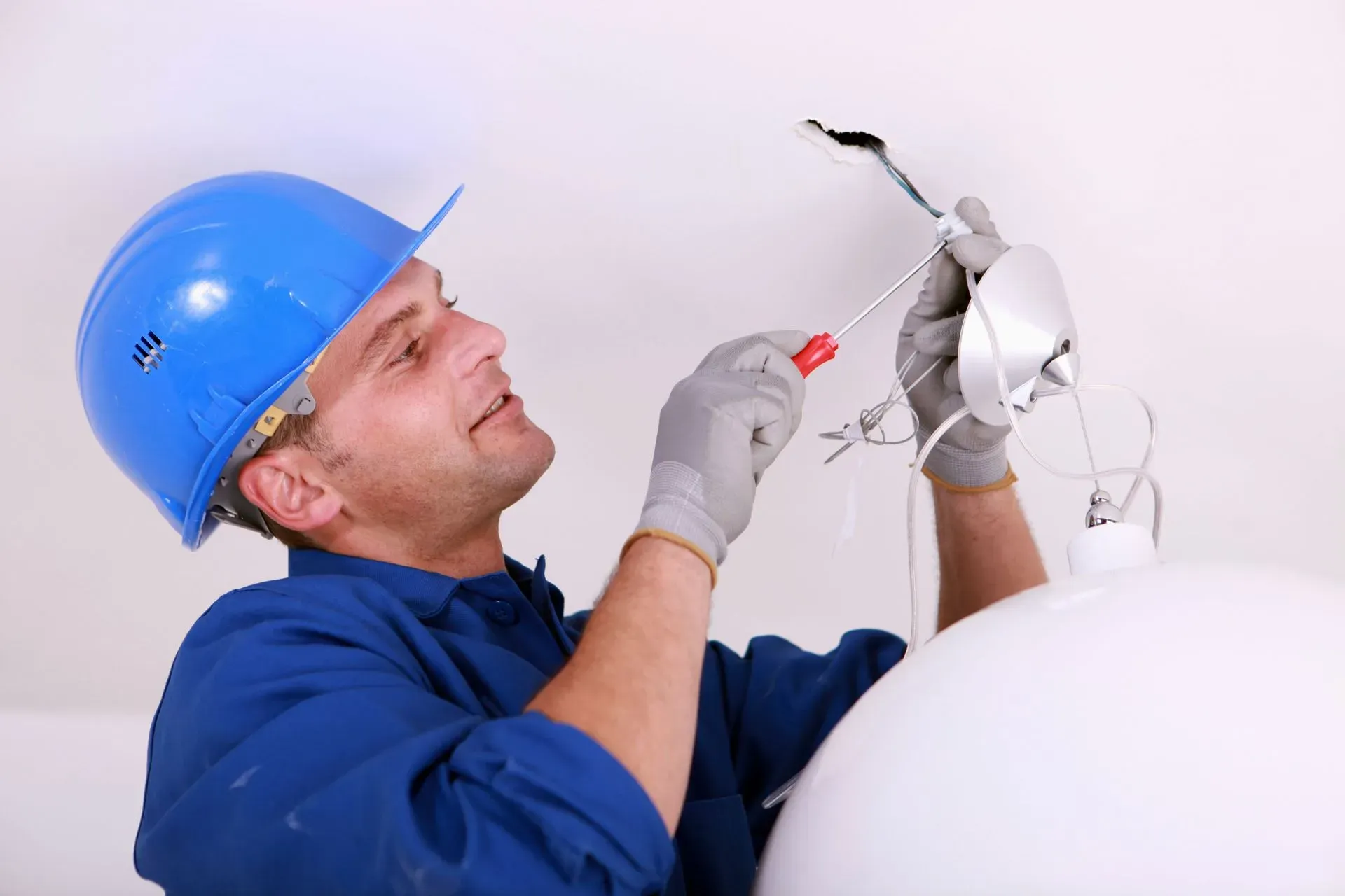 Electrician installing a ceiling light fixture