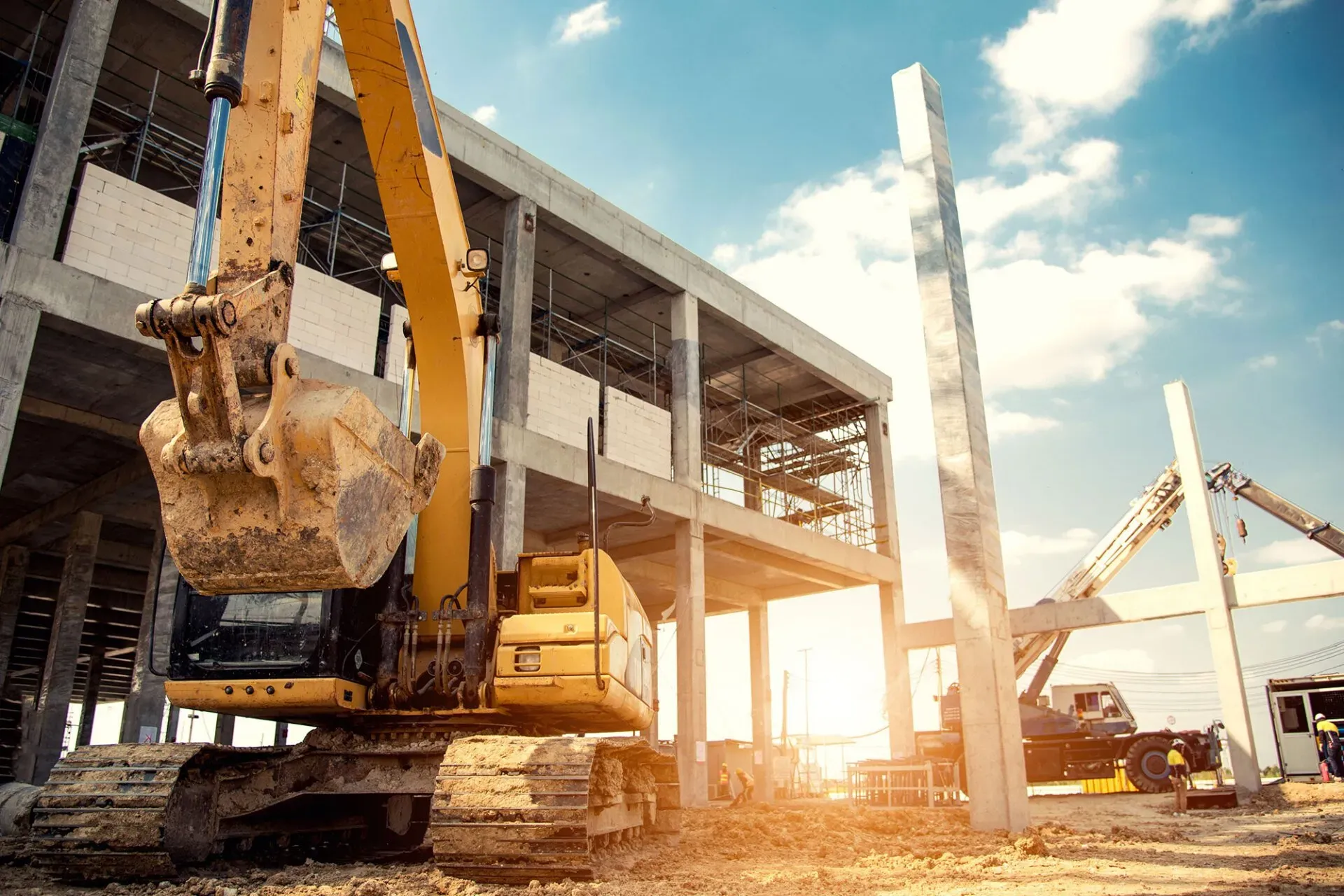 Excavator and cranes on building site.